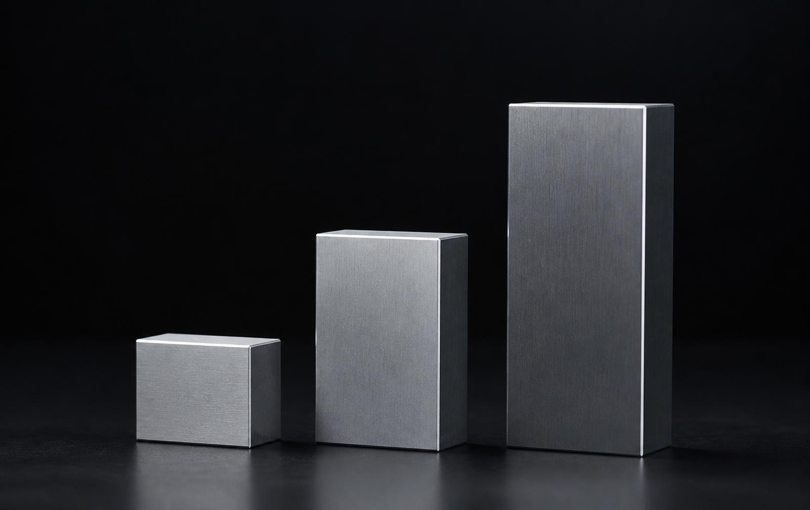 Precision machined weights balanced on a dark surface
